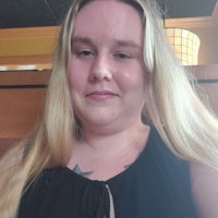 a woman with long blonde hair sitting in a restaurant